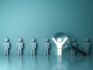 A magnifying glass hovering over a glowing person icon with their arms up, standing in a line of similar icons and symbolizing selecting the right Southwest Florida property management firm.