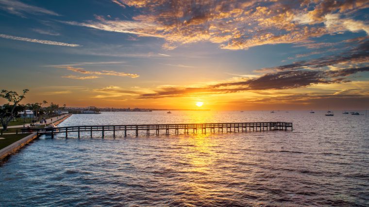 A sunset over a pier in Gilchrist Park, Punta Gorda, Peace River, Punta Gorda, Florida. 